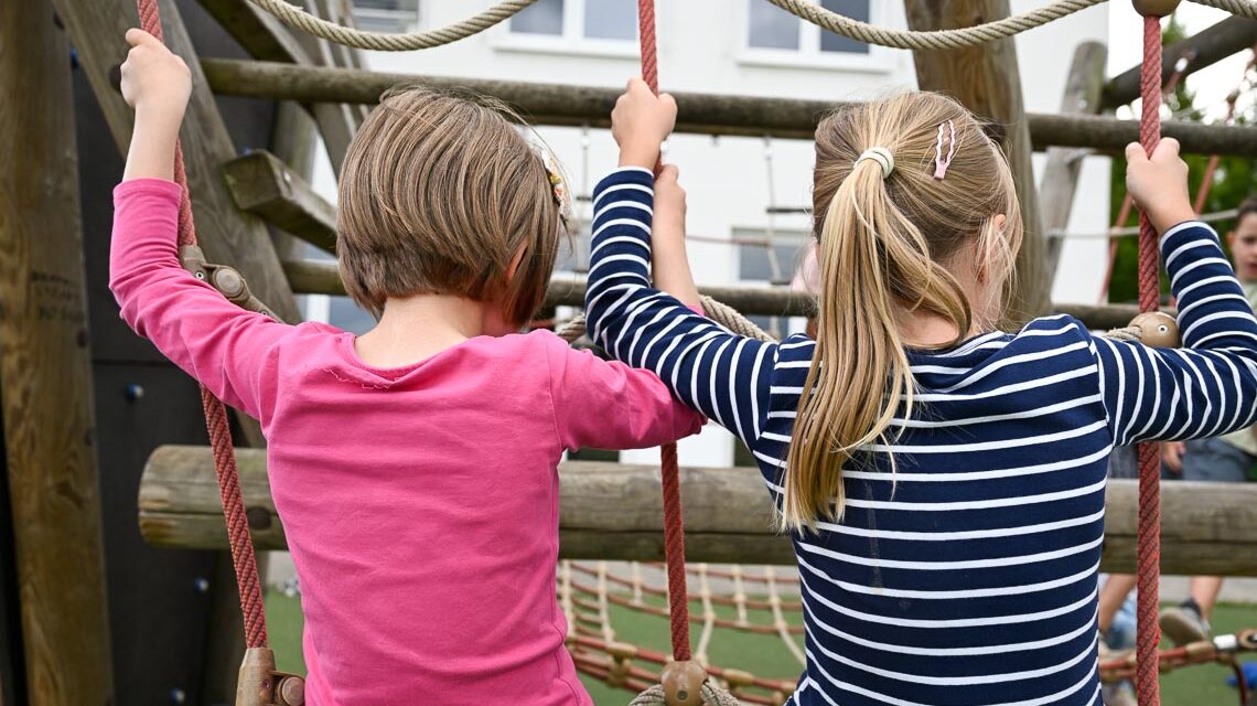 Schüler am Campus Erbenheim sitzen auf einem Klettergerüst und tauschen sich aus.