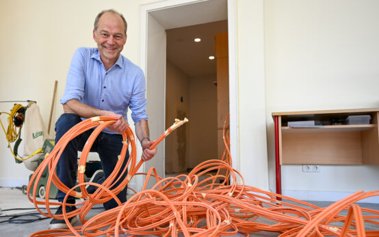 Dr. Gerhard Obermayr zeigt bei einem Rundgang den Fortschritt der Digitalisierung: Eine Hand voll LAN-Kabel.